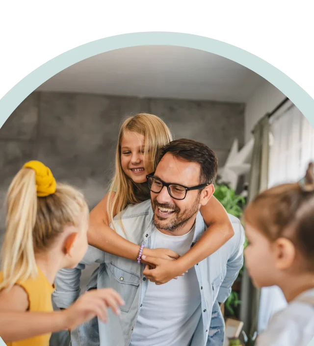 Dad with his 3 young girls smiling in their home
